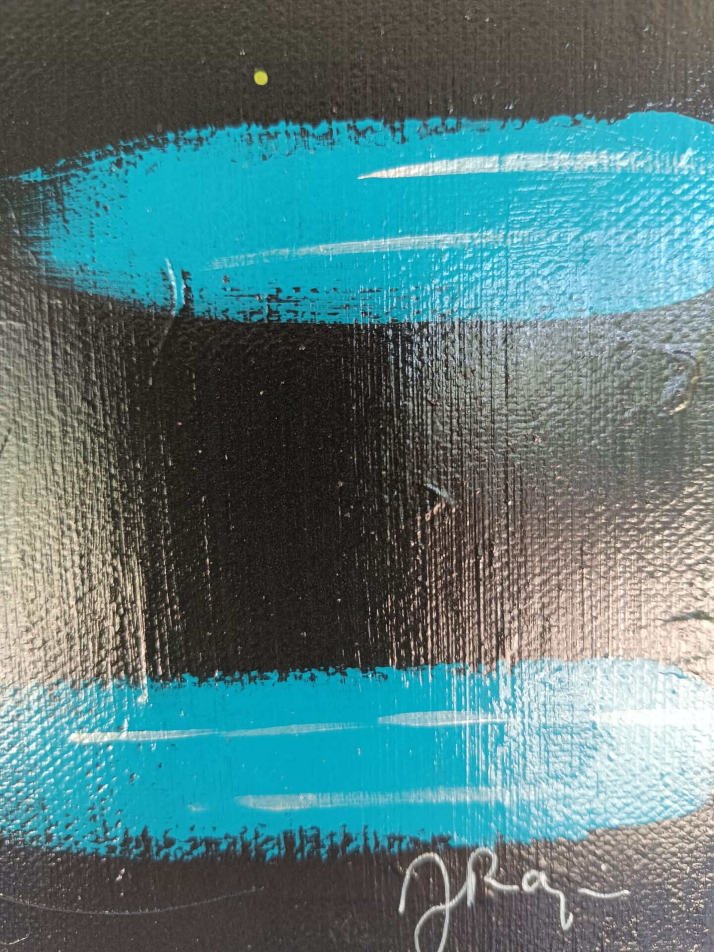Gros plan sur la signature de l'artiste Jocelyne Malek sur le tableau gris anthracite.