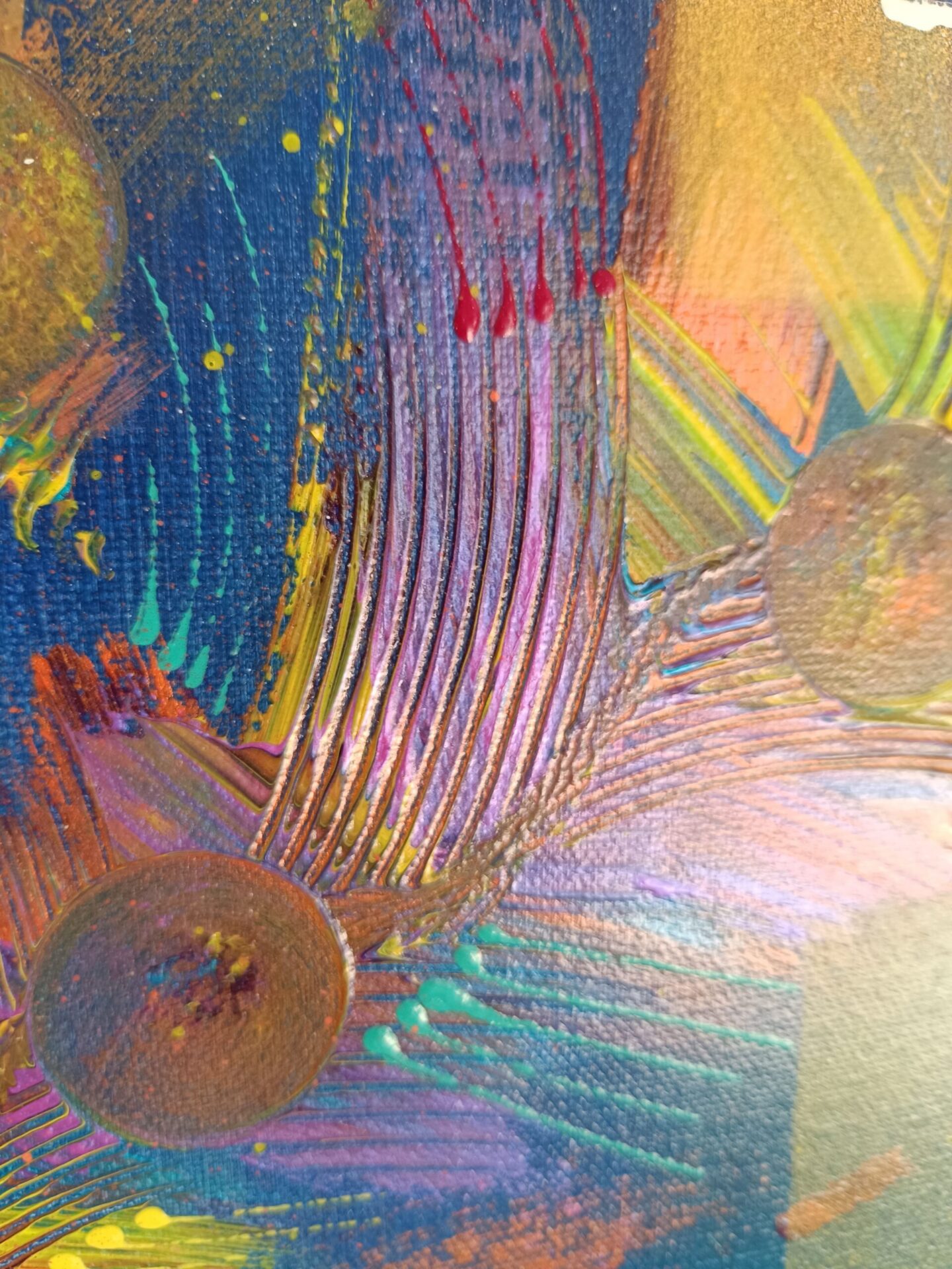 Détail des reliefs sur la plume multicolore et les projections colorées.