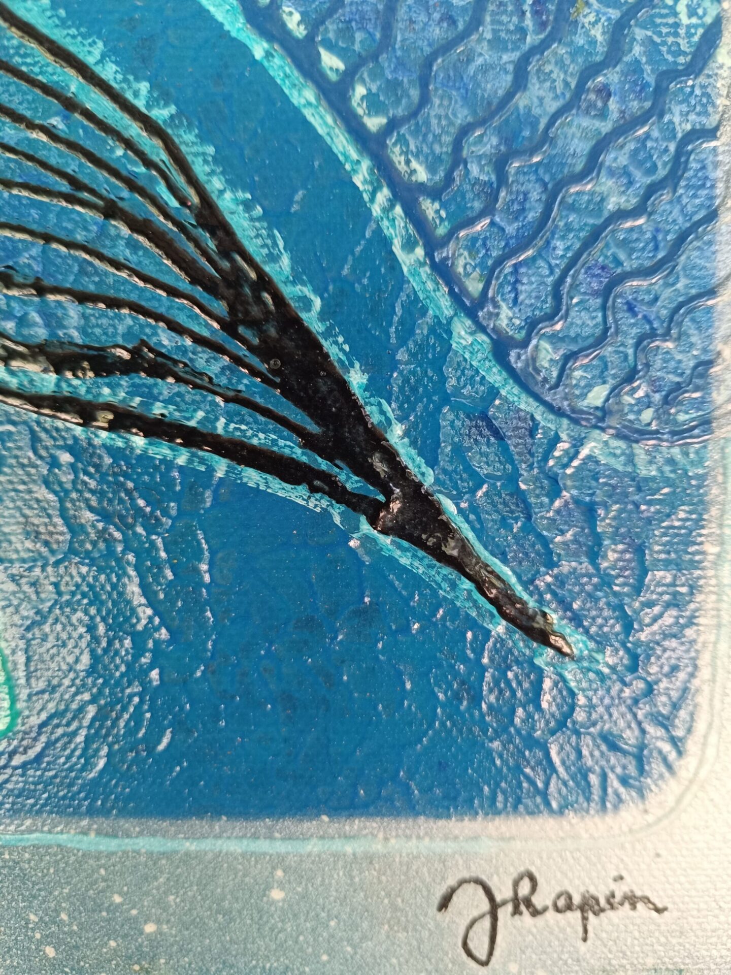 Gros plan sur la signature de l'artiste Jocelyne Malek sur la peinture bleu jean.